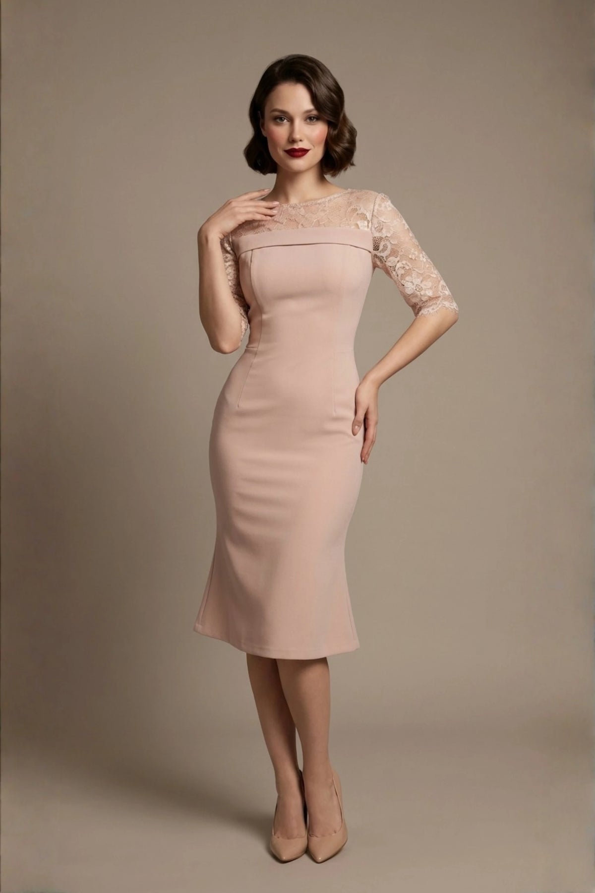 Woman wearing a diva catwalk Francesca Lace Fluted Dress in pink haze colour dress with lace sleeves against a brown background front (Pink Haze)
