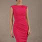 Woman wearing a pink dress against a brown background (Paradise Pink)