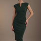 Woman wearing a green dress against a brown background (Deep Green)