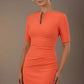 Woman wearing an orange dress against a brown background (Sea Coral)