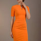 Woman wearing an orange dress against a brown background (Sun Orange)