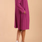 model wearing diva catwalk teal coat with long sleeves and a belt in Orchid Purple side back