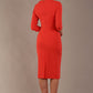 model wearing diva catwalk ubrique pencil dress with a keyhole detail and sleeves in Grenadine Orange  (Grenadine Orange)