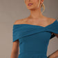 model wearing diva catwalk vegas calf length Teal midaxi dress with wide bardot neckline and open shoulders with a large opening at the front of the skirt with pleating coming down long skirt front close-up (Tropical Teal)