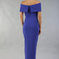 model wearing diva catwalk vegas calf length spectrum indigo midaxi dress with wide bardot neckline and open shoulders with a large opening at the front of the skirt with pleating coming down long skirt back (Spectrum Indigo)