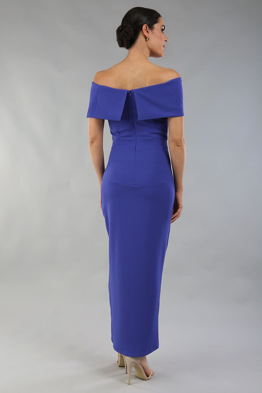 model wearing diva catwalk vegas calf length spectrum indigo midaxi dress with wide bardot neckline and open shoulders with a large opening at the front of the skirt with pleating coming down long skirt back (Spectrum Indigo)