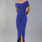 model wearing diva catwalk vegas calf length spectrum indigo midaxi dress with wide bardot neckline and open shoulders with a large opening at the front of the skirt with pleating coming down long skirt front (Spectrum Indigo)