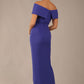 model wearing diva catwalk vegas calf length spectrum indigo midaxi dress with wide bardot neckline and open shoulders with a large opening at the front of the skirt with pleating coming down long skirt back (Spectrum Indigo)