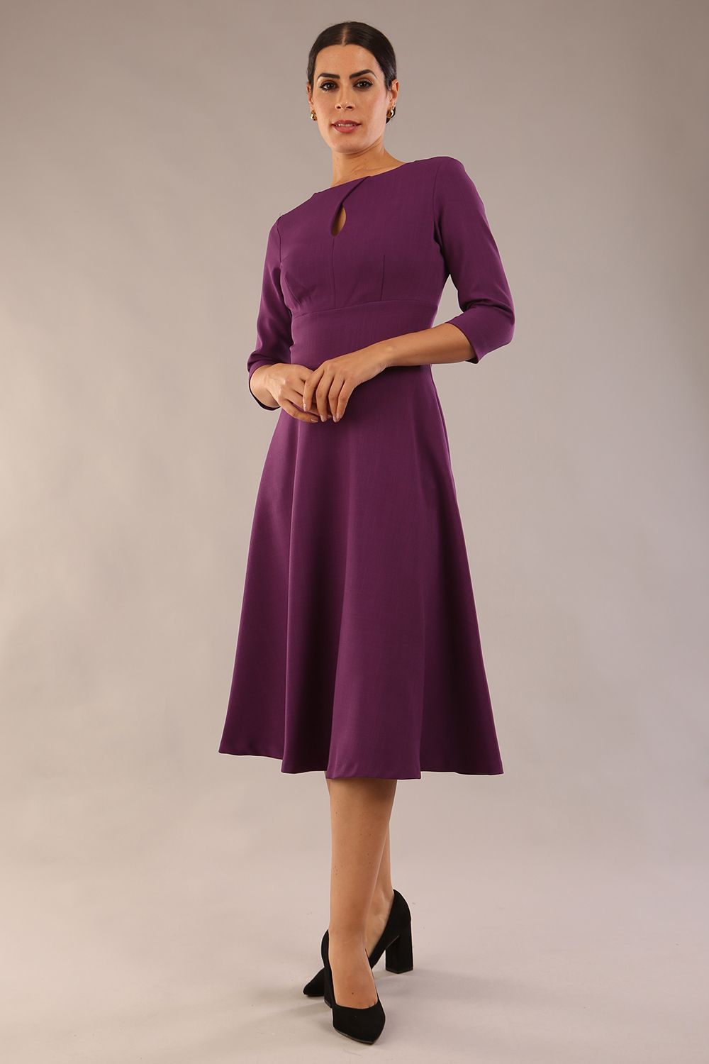Brunette model is wearing diva catwalk casares swing dress with a keyhole neckline three quarter sleeve dress with pocket detail in imperial purple side front (Imperial Purple)