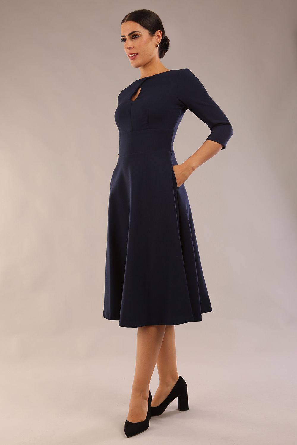 Brunette  model is wearing diva catwalk casares swing dress with a keyhole neckline three quarter sleeve dress with pocket detail in navy blue front (Navy Blue)