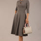 Brunette model is wearing diva catwalk casares swing dress with a keyhole neckline three quarter sleeve dress with pocket detail in Castlerock Grey  front (Castlerock Grey)