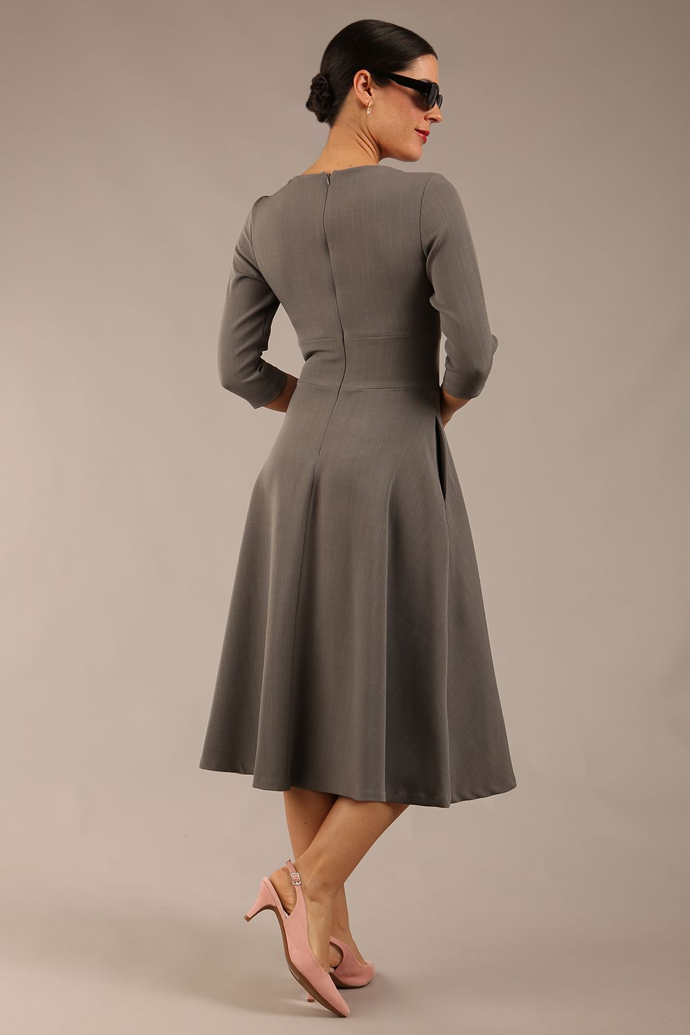 Brunette model is wearing diva catwalk casares swing dress with a keyhole neckline three quarter sleeve dress with pocket detail in Castlerock Grey  back (Castlerock Grey)