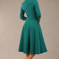 Brunette model is wearing diva catwalk casares swing dress with a keyhole neckline three quarter sleeve dress with pocket detail in Parasailing green back (Parasailing Green)