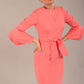 A model wearing a pink knee-length pencil dress with ruffled sleeves and a waist belt, standing against a plain background (Dahlia Pink)