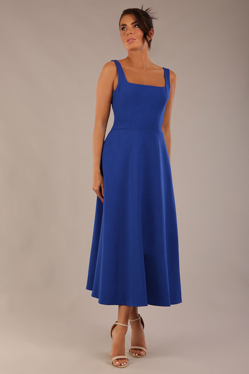 brunette model wearing a diva catwalk Tamsin Square Neckline Swing Dress sleeveless style with a midaxi  length and side pockets in cobalt blue colour front (Cobalt blue)