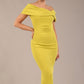 model is wearing a diva catwalk Mariposa Longer Length Dress off the shoulder bardot neckline and midaxi length in citrus green colour