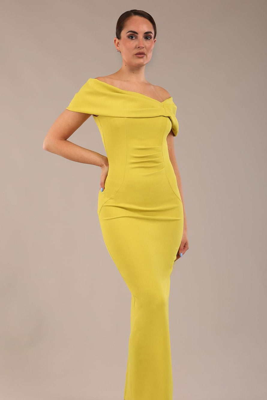 model is wearing a diva catwalk Mariposa Longer Length Dress off the shoulder bardot neckline and midaxi length in citrus green colour