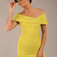 brunette model is wearing a diva catwalk Mariposa Longer Length Dress off the shoulder bardot neckline and midaxi length in citrus green colour front image with sunglasses