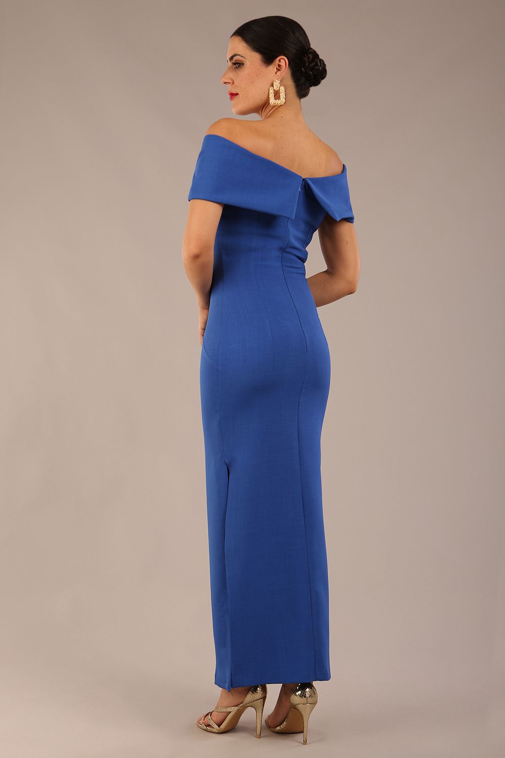 brunette model is wearing a diva catwalk Mariposa Longer Length Dress off the shoulder bardot neckline and midaxi length in cobalt blue colour back image