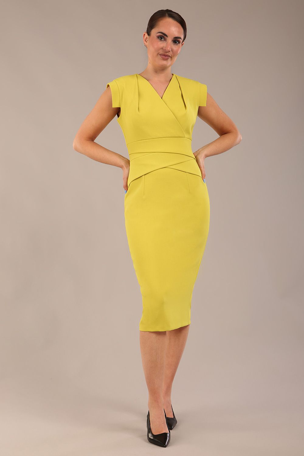 model wearing a diva catwalk Caprice Cap Sleeved Pencil Dress cap sleeve v neckline knee length with pleating details in citrus green colour (Citrus Green)