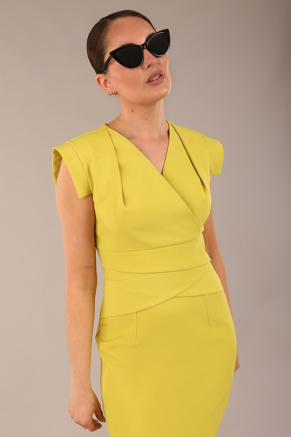 model wearing a diva catwalk Caprice Cap Sleeved Pencil Dress cap sleeve v neckline knee length with pleating details in citrus green colour (Citrus Green)