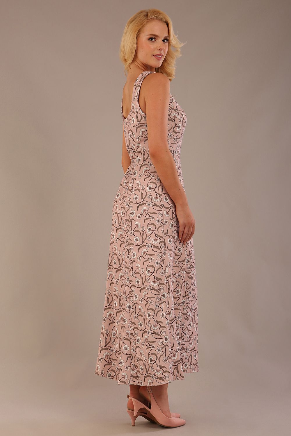 blonde model is wearing a 7000 diva catwalk Glyndebourne Sleeveless Square Neck Maxi Dress in tudor vine print with pockets back