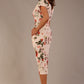 brunette model is wearing a 7002 diva catwalk Carlisle Boat Neck Short Sleeve Midi Pencil Dress in Rose Blush print with side pockets back side