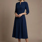 Woman wearing a diva catwalk Amanda Pleated a-line dress in a magenta pink colour against a beige background (Navy Blue)