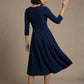 Woman wearing a diva catwalk Amanda Pleated a-line dress in a magenta pink colour against a beige background (Navy Blue)