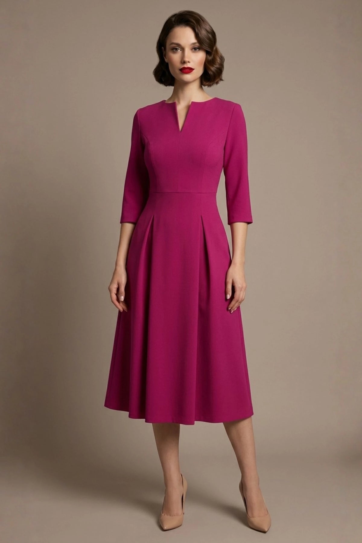 Woman wearing a diva catwalk Amanda Pleated a-line dress in a magenta pink colour against a beige background (Magenta)