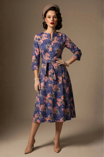 A model showcasing the vintage-inspired Zuleika floral midi dress, styled with retro accessories, highlighting the cinched tie-waist and V-notch neckline (Chelsea Garden Bloom Print)