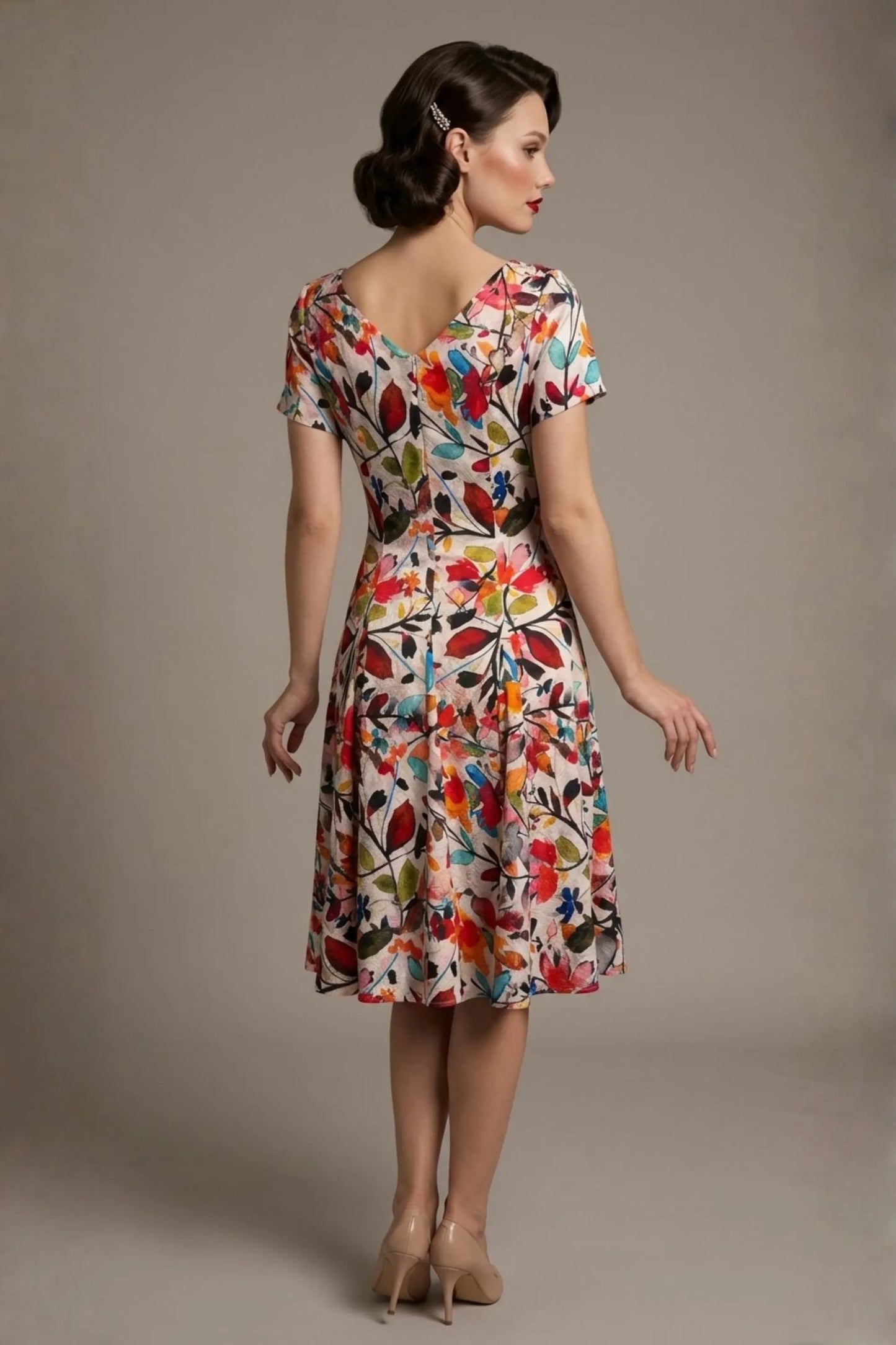 Woman wearing a diva catwalk colorful floral dress called Valia Silk Touch A-Line Dress against a plain background (Erratic Leaf Print)
