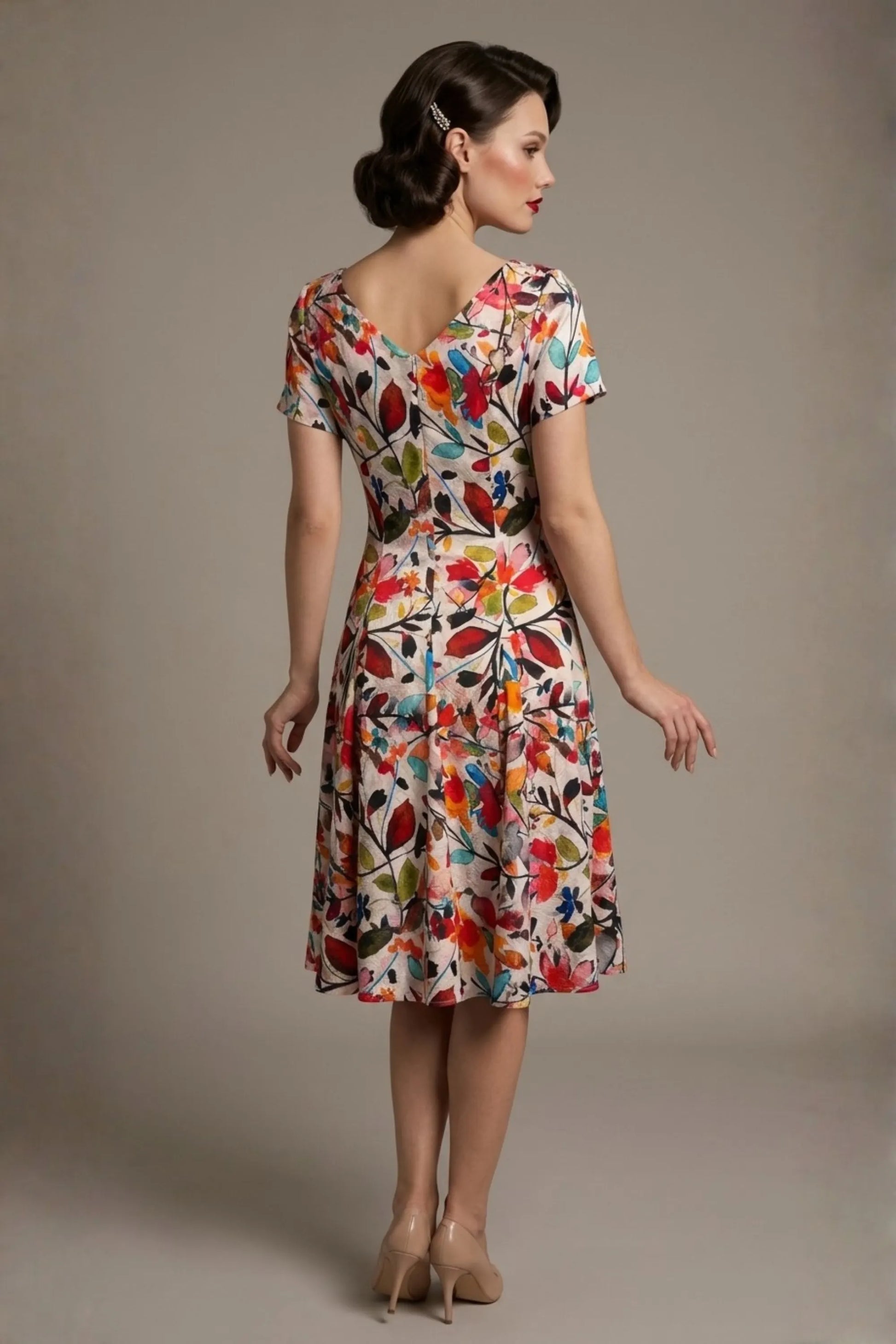 Woman wearing a diva catwalk colorful floral dress called Valia Silk Touch A-Line Dress against a plain background (Erratic Leaf Print)