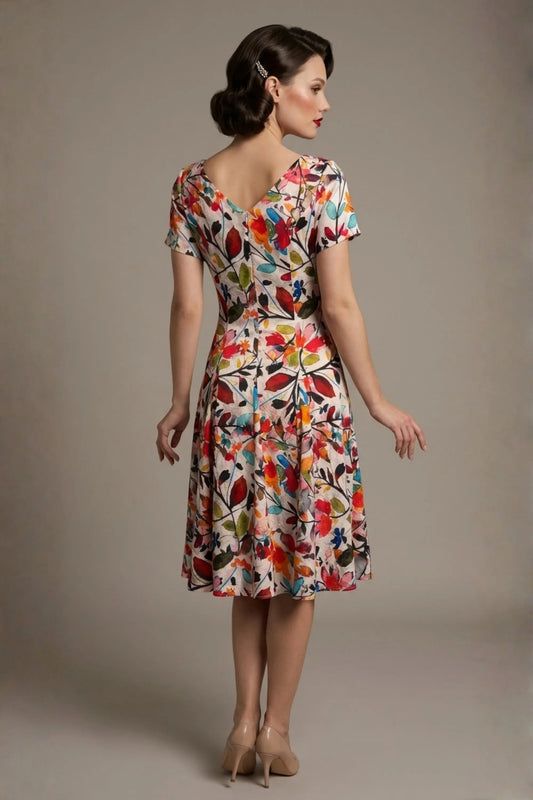Woman wearing a diva catwalk colorful floral dress called Valia Silk Touch A-Line Dress against a plain background (Erratic Leaf Print)