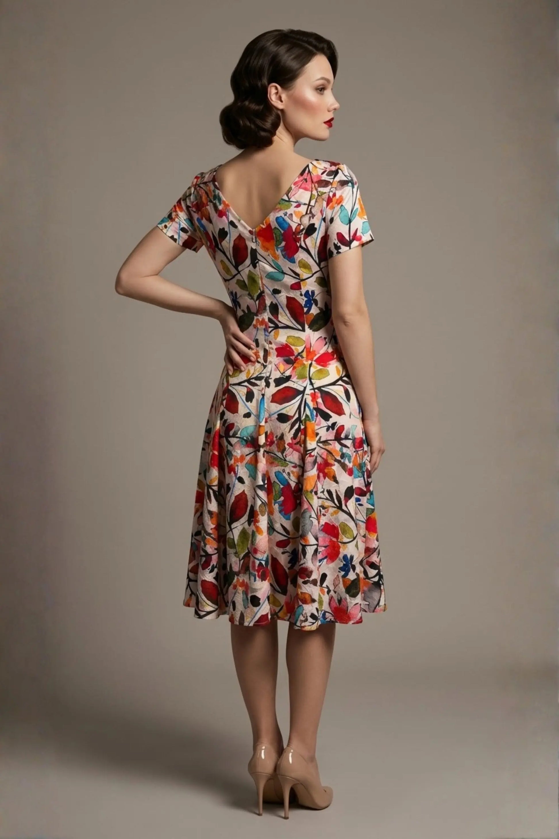 Woman wearing a diva catwalk colorful floral dress called Valia Silk Touch A-Line Dress against a plain background (Erratic Leaf Print)